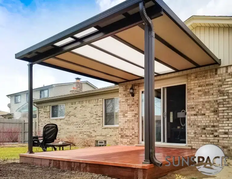 Hybrid patio cover by Sunspace, featuring a sturdy structure with a translucent roof, enhancing outdoor living space in a residential setting.