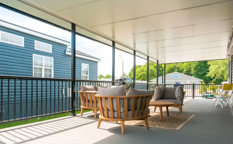 Patio cover featuring comfortable seating area with wooden chairs and a table, enhancing outdoor living space for relaxation and enjoyment.