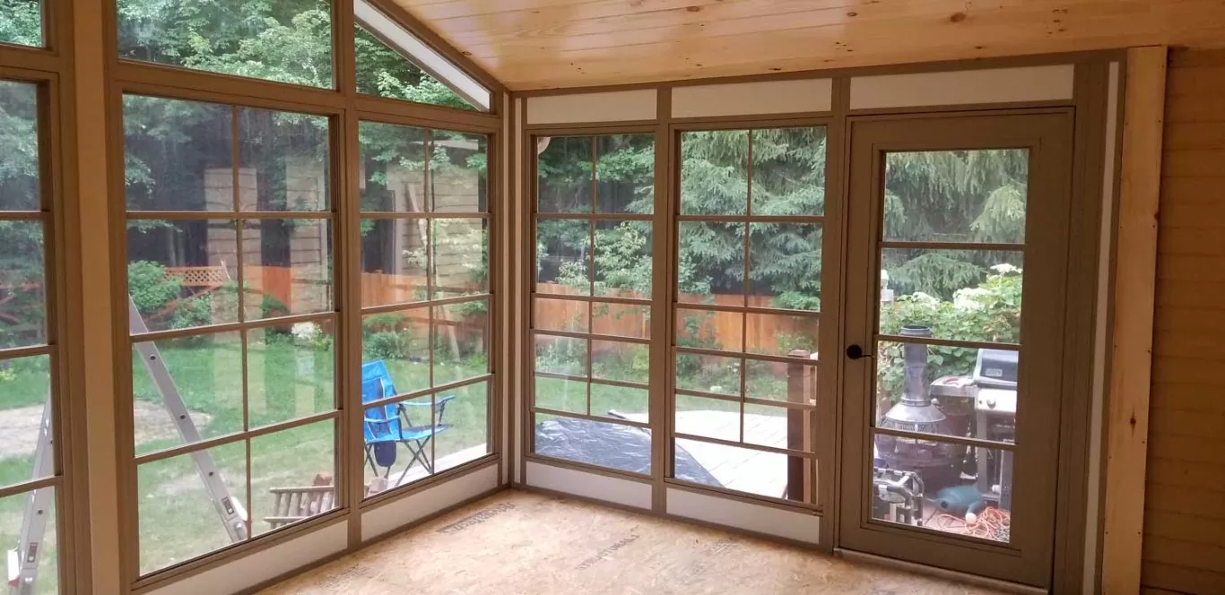 WeatherMaster Windows featuring fiberglass mesh screens, providing ventilation and insect protection in a sunroom setting with outdoor views.